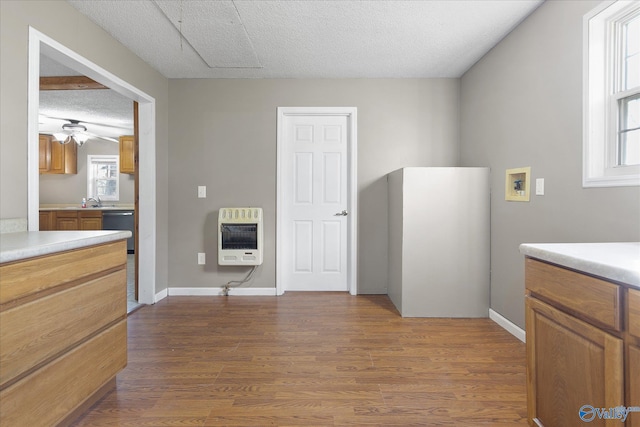 bathroom with hardwood / wood-style flooring, ceiling fan, a textured ceiling, and heating unit