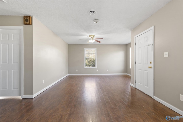 unfurnished room with a textured ceiling, ceiling fan, and dark hardwood / wood-style floors