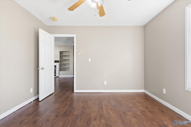 unfurnished room with dark hardwood / wood-style floors, ceiling fan, and built in shelves