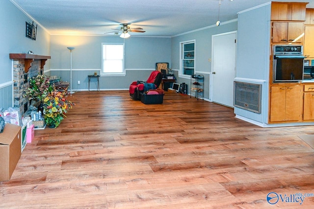 recreation room featuring light hardwood / wood-style floors, ceiling fan, a textured ceiling, and crown molding