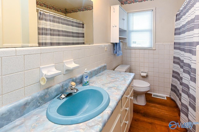 bathroom featuring tile walls, vanity, hardwood / wood-style flooring, and toilet