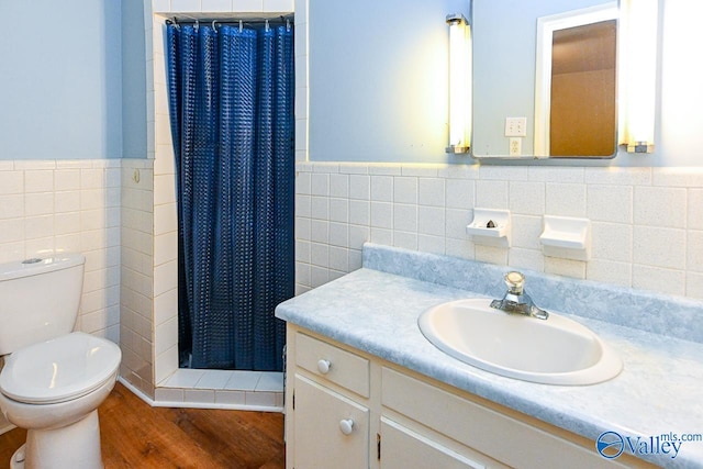 bathroom with a shower with shower curtain, toilet, tile walls, and hardwood / wood-style floors