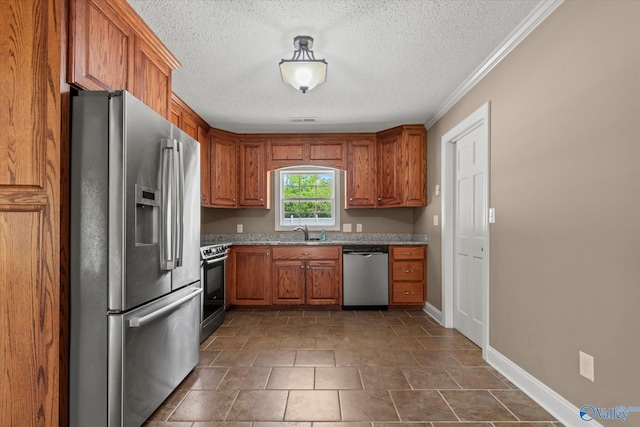 kitchen featuring light stone counters, brown cabinets, appliances with stainless steel finishes, and a textured ceiling