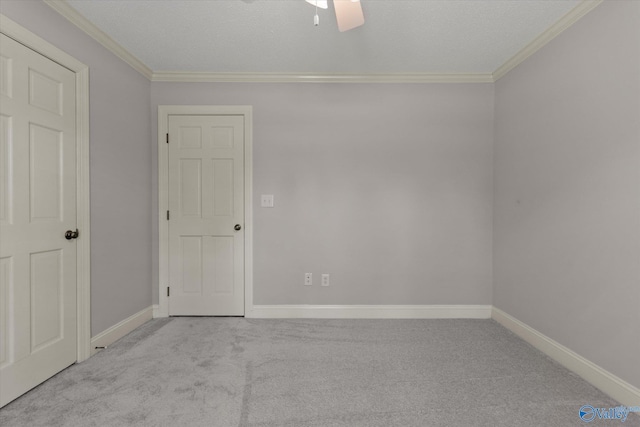 carpeted empty room featuring baseboards, ceiling fan, and crown molding