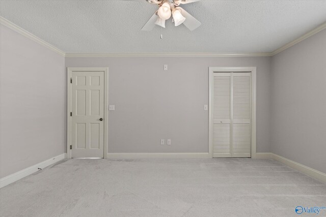 unfurnished bedroom with a closet, ornamental molding, a textured ceiling, and carpet