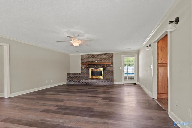 unfurnished living room with dark wood finished floors, a textured ceiling, crown molding, a brick fireplace, and ceiling fan