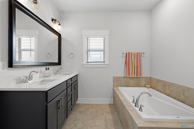 bathroom with a relaxing tiled tub, vanity, tile patterned flooring, and a wealth of natural light