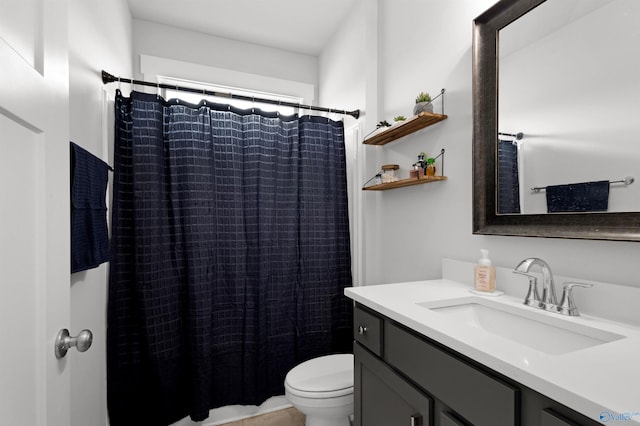 bathroom featuring vanity, walk in shower, and toilet