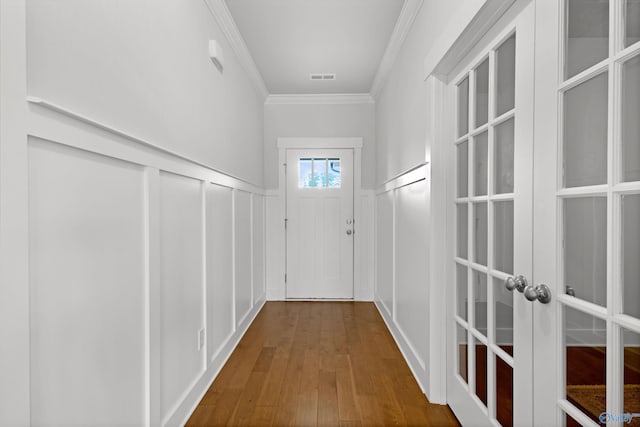 doorway with crown molding, wood-type flooring, and french doors