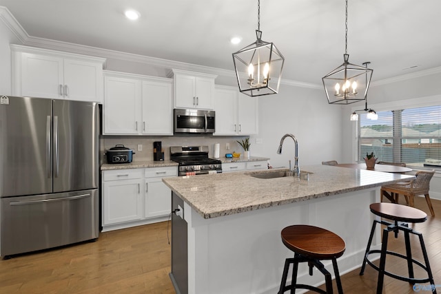 kitchen with stainless steel appliances, white cabinetry, and pendant lighting