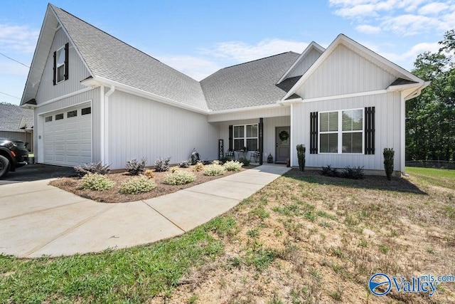 view of front of house with a garage, a front yard, and a porch