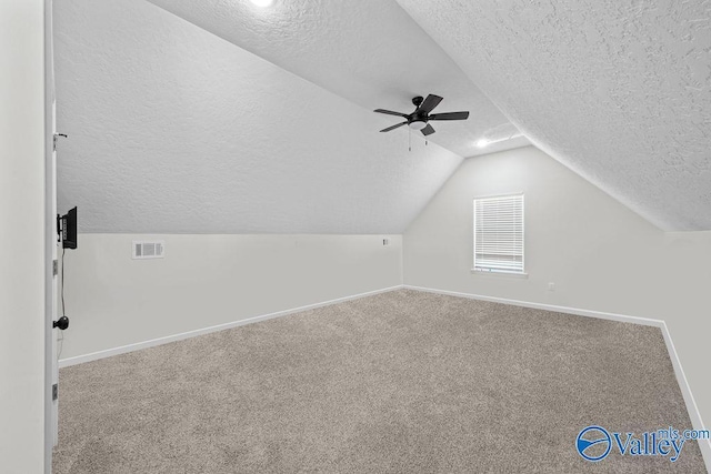 bonus room with vaulted ceiling, ceiling fan, carpet floors, and a textured ceiling