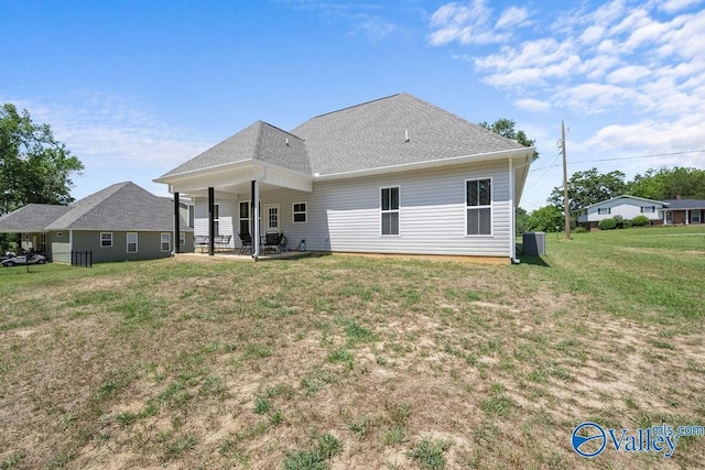 back of property with central AC unit, a patio area, and a lawn