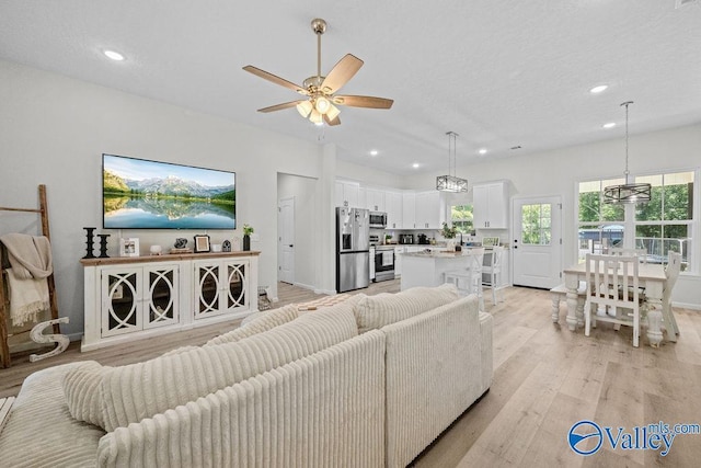 living room featuring ceiling fan and light hardwood / wood-style floors