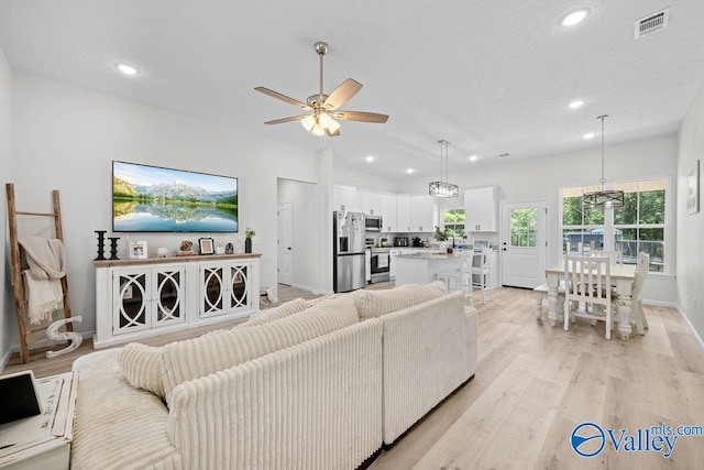 living room with ceiling fan and light hardwood / wood-style floors