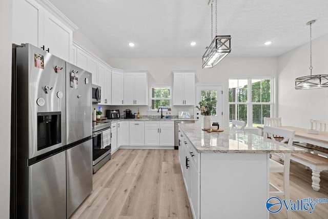 kitchen with white cabinetry, appliances with stainless steel finishes, sink, and pendant lighting