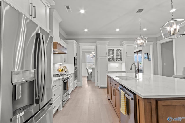 kitchen featuring stainless steel appliances, sink, light hardwood / wood-style floors, white cabinetry, and ornamental molding