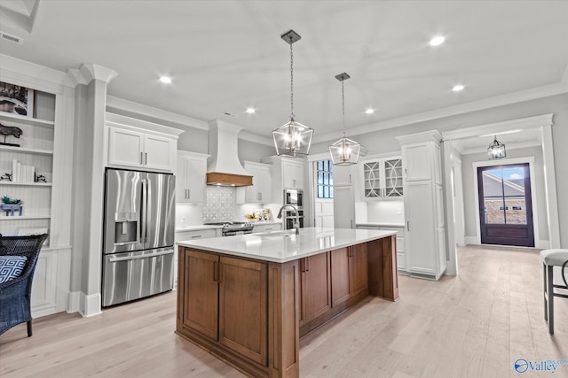 kitchen featuring appliances with stainless steel finishes, light wood-type flooring, white cabinets, and custom range hood