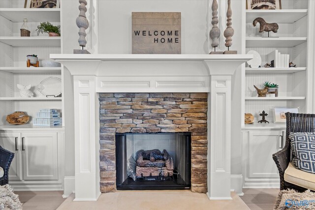 interior details with wood-type flooring and a stone fireplace