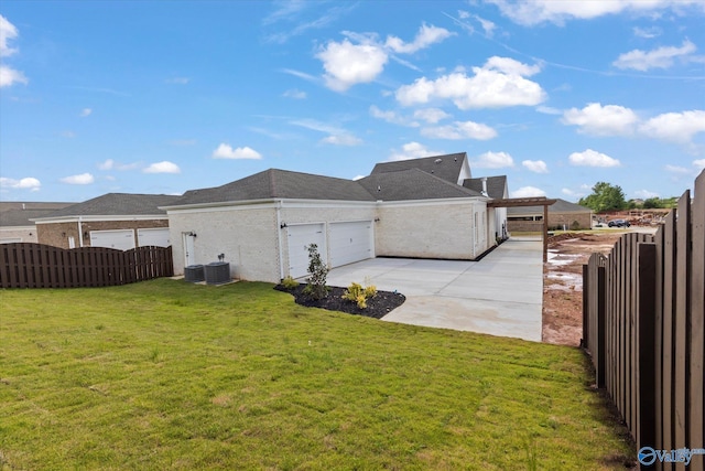 view of side of home with a garage, a lawn, and cooling unit