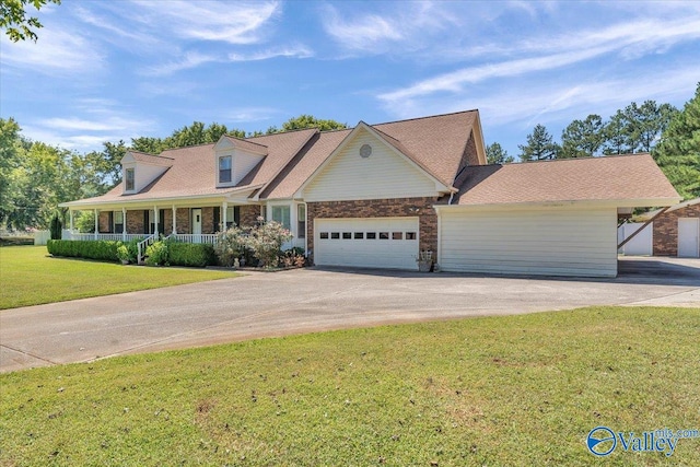 view of front of home featuring a garage, a front yard, and a porch