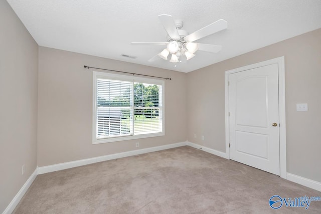 carpeted empty room featuring ceiling fan