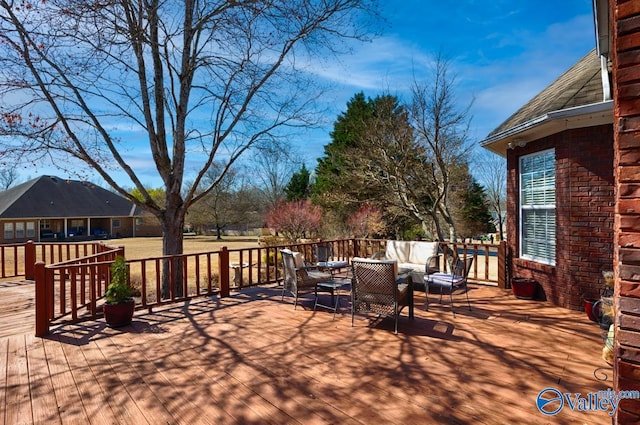 wooden terrace with an outdoor living space