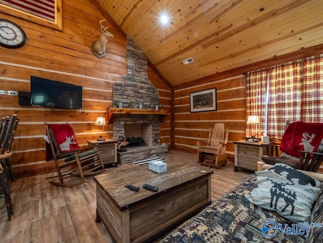 living room featuring wooden ceiling, high vaulted ceiling, a stone fireplace, and light hardwood / wood-style floors