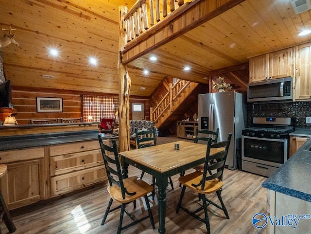 kitchen with appliances with stainless steel finishes, wood walls, light wood-type flooring, and wood ceiling