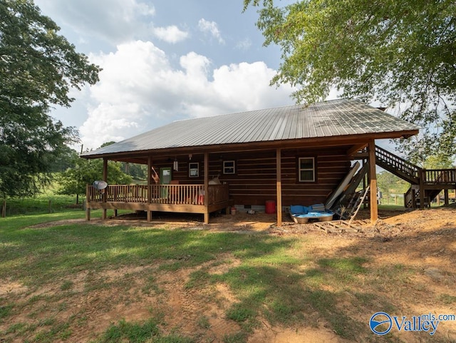 rear view of property with a deck and a yard