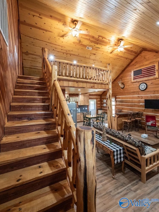 interior space featuring wooden ceiling, ceiling fan, wood-type flooring, and wooden walls