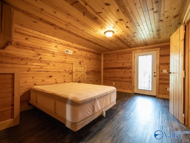 bedroom featuring wood walls, wood ceiling, and dark wood-type flooring