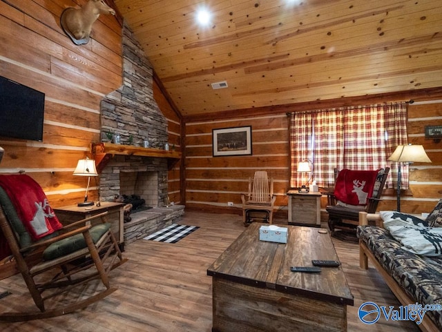 living room with hardwood / wood-style floors, wooden ceiling, a stone fireplace, high vaulted ceiling, and wood walls