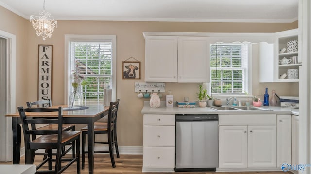 kitchen with a wealth of natural light, stainless steel dishwasher, ornamental molding, and a sink