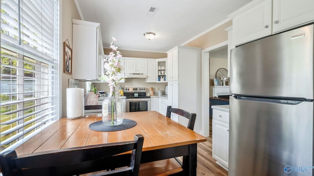 dining space featuring crown molding, wood finished floors, and visible vents
