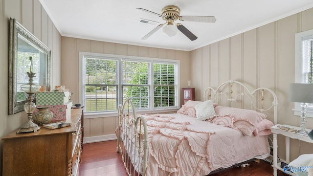 bedroom featuring dark wood finished floors, a decorative wall, and ornamental molding