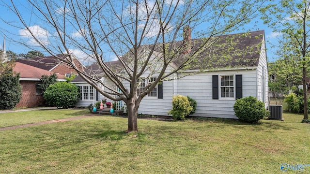view of front facade featuring central AC, a front lawn, and a shingled roof