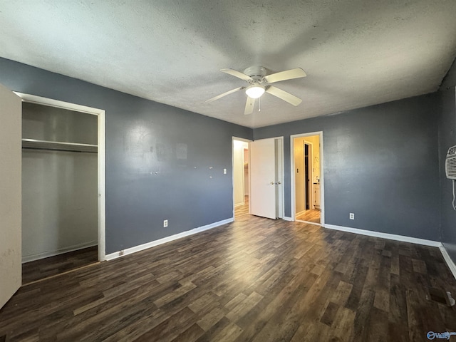 unfurnished bedroom featuring a closet, dark hardwood / wood-style floors, a textured ceiling, and ceiling fan