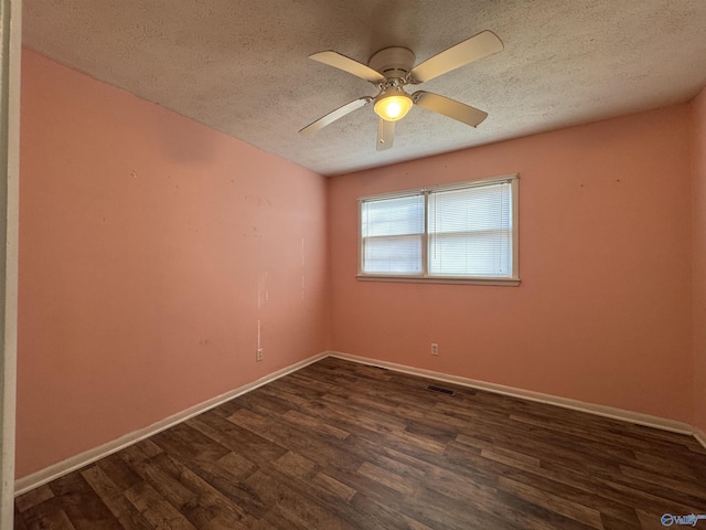 spare room featuring ceiling fan, dark wood-type flooring, and a textured ceiling