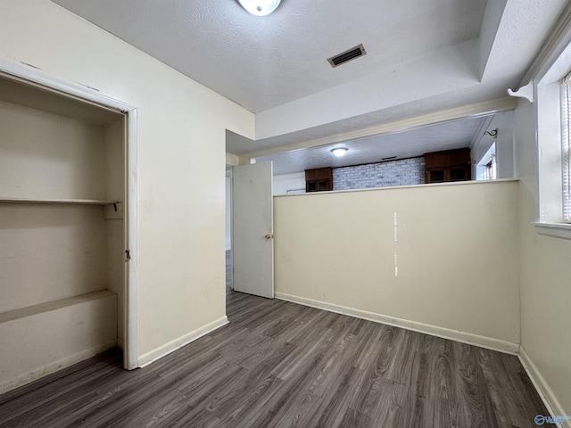 unfurnished bedroom featuring dark hardwood / wood-style flooring, a closet, and a textured ceiling