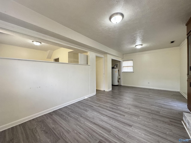 basement with hardwood / wood-style flooring, water heater, and a textured ceiling