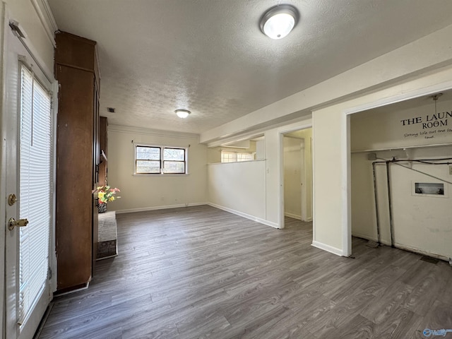 basement featuring wood-type flooring and a textured ceiling