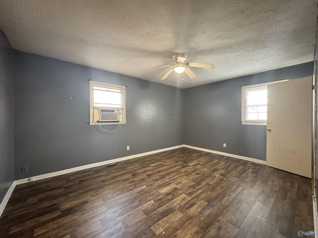 empty room with dark hardwood / wood-style floors, a wealth of natural light, and ceiling fan