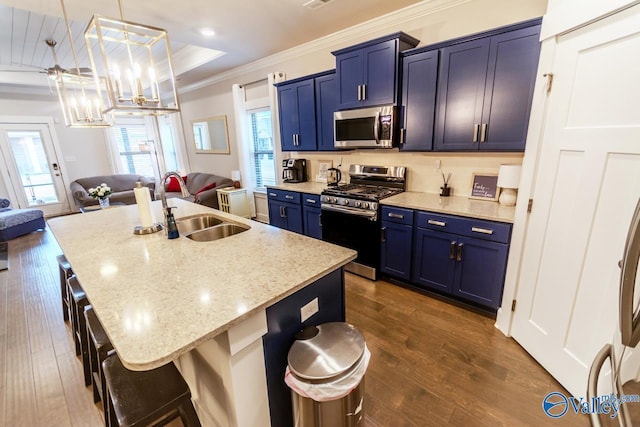 kitchen with a center island with sink, hanging light fixtures, appliances with stainless steel finishes, and dark wood-type flooring