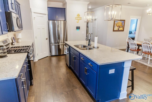 kitchen featuring sink, blue cabinets, stainless steel appliances, and an island with sink