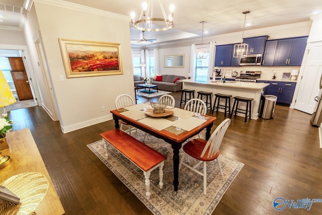 dining space featuring dark hardwood / wood-style floors, ornamental molding, and sink