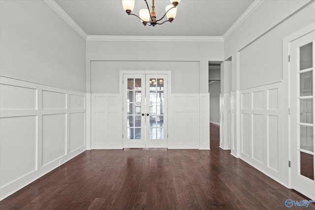 spare room featuring dark hardwood / wood-style flooring, french doors, an inviting chandelier, and crown molding