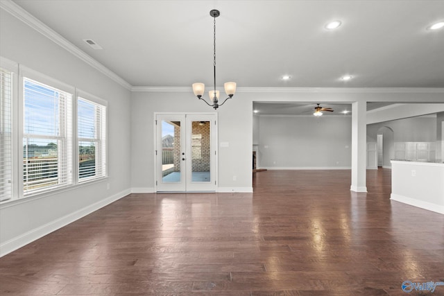 unfurnished dining area featuring ceiling fan with notable chandelier, french doors, crown molding, and dark hardwood / wood-style flooring