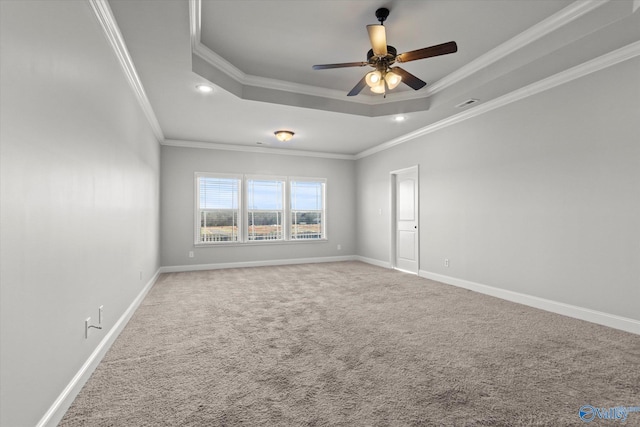 carpeted empty room with ornamental molding, ceiling fan, and a tray ceiling