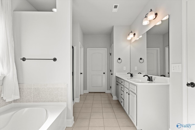 bathroom with a bath, tile patterned floors, and vanity